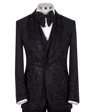 Front view of a black hand-embellished tuxedo with intricate beadwork and sequin patterns, displayed on a mannequin. Features a single-breasted jacket, peak lapel, matching vest, and trousers, embodying luxury bespoke craftsmanship from Istanbul.