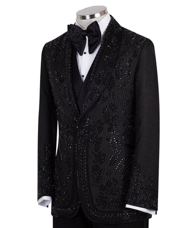 Front view of a black hand-embellished tuxedo with intricate beadwork and sequin patterns, displayed on a mannequin. Features a single-breasted jacket, peak lapel, matching vest, and trousers, embodying luxury bespoke craftsmanship from Istanbul.