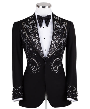 Black embellished three-piece tuxedo with intricate crystal and bead patterns on satin peak lapels, chest, and cuffs. Features a matching vest. Handcrafted luxury suit from BTS Bespoke Istanbul.