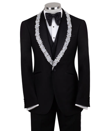 Full front view of a black three-piece tuxedo on a mannequin, featuring heavily hand-embellished shawl lapels with pearls and crystals, and a matching embellishment down the side of the trousers. Includes a black double-breasted vest and a white shirt with a black bow tie (not included).