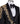 Front view of a black jacquard three-piece tuxedo with intricate gold hand-embellishments on the shawl lapel, shoulder, and cuffs, displayed on a mannequin. From BTS Bespoke, handcrafted in Istanbul.