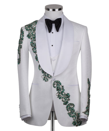 BTS Bespoke white three-piece tuxedo with intricate emerald green hand-embellished details on the jacket, shoulders, and sleeves. Features a white shawl lapel and vest. Front view and side view of the luxury suit on a mannequin.