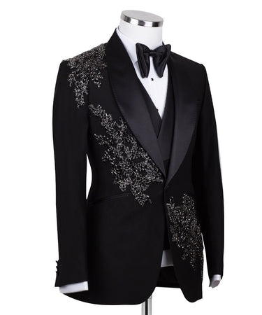 BTS Bespoke Black Embellished Three-Piece Tuxedo. Handcrafted single-breasted jacket with peak lapel and shimmering crystal embellishments. Includes matching double-breasted vest and trousers.