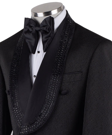 Front view of a black textured double-breasted tuxedo with hand-embellished shawl lapels, cuffs, and front trim. The trousers have a satin side stripe. High-end luxury formal wear from BTS Bespoke.