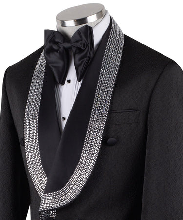 Black double-breasted tuxedo jacket with intricate silver hand-embellished shawl lapels, front detail, and cuffs, paired with black satin stripe trousers on a mannequin. From BTS Bespoke, handcrafted in Istanbul.
