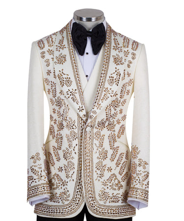 Cream and gold hand-embellished tuxedo jacket, vest, and black trousers from BTS Bespoke, handcrafted in Istanbul. Features intricate floral metallic stud detailing on a slim-fit, peak lapel design.