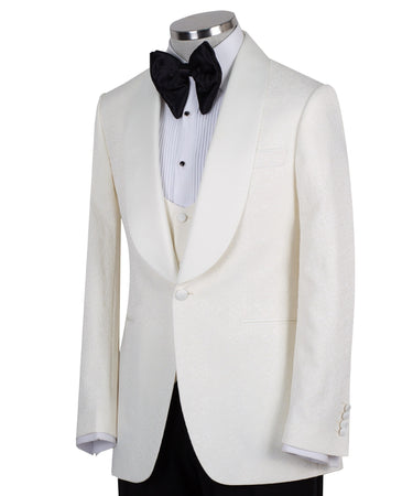 Front view of an ivory jacquard three-piece tuxedo with black trousers on a mannequin. Features a single-breasted jacket with a satin shawl lapel, matching U-neck vest, and subtle floral pattern. Ideal for weddings and formal events.