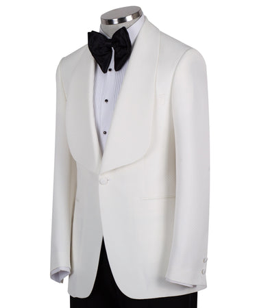 White textured shawl lapel tuxedo jacket and black trousers by BTS Bespoke, handcrafted in Istanbul. View shows single-button closure and elegant detailing.