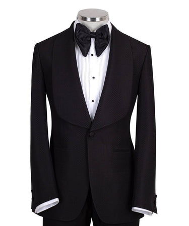 Black single-breasted tuxedo with subtle jacquard pattern and elegant shawl lapel, handcrafted in Istanbul by BTS Bespoke, front view on mannequin.