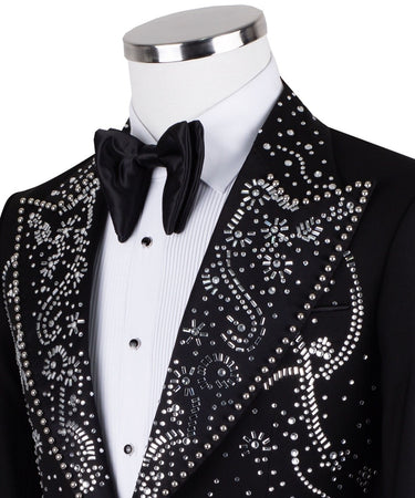 Black embellished three-piece tuxedo with intricate crystal and bead patterns on satin peak lapels, chest, and cuffs. Features a matching vest. Handcrafted luxury suit from BTS Bespoke Istanbul.