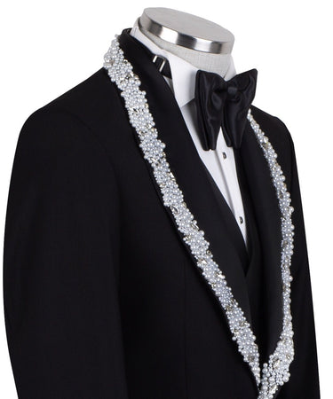 Full front view of a black three-piece tuxedo on a mannequin, featuring heavily hand-embellished shawl lapels with pearls and crystals, and a matching embellishment down the side of the trousers. Includes a black double-breasted vest and a white shirt with a black bow tie (not included).
