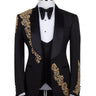 Front view of a black jacquard three-piece tuxedo with intricate gold hand-embellishments on the shawl lapel, shoulder, and cuffs, displayed on a mannequin. From BTS Bespoke, handcrafted in Istanbul.