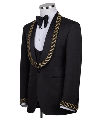 Front view of BTS Bespoke's black jacquard three-piece tuxedo with opulent gold chain embellishments on the shawl lapel and cuffs, tailored in Istanbul. Includes jacket, vest, and trousers.