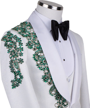 BTS Bespoke white three-piece tuxedo with intricate emerald green hand-embellished details on the jacket, shoulders, and sleeves. Features a white shawl lapel and vest. Front view and side view of the luxury suit on a mannequin.