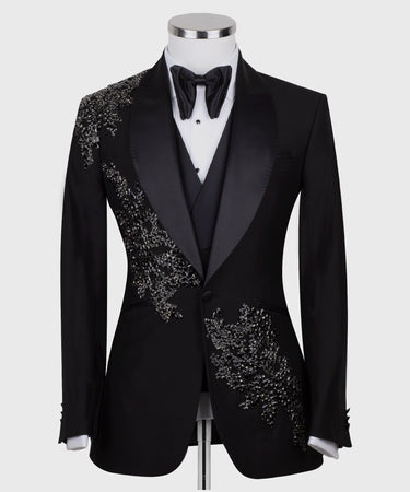 BTS Bespoke Black Embellished Three-Piece Tuxedo. Handcrafted single-breasted jacket with peak lapel and shimmering crystal embellishments. Includes matching double-breasted vest and trousers.