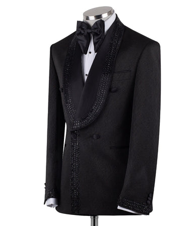 Front view of a black textured double-breasted tuxedo with hand-embellished shawl lapels, cuffs, and front trim. The trousers have a satin side stripe. High-end luxury formal wear from BTS Bespoke.