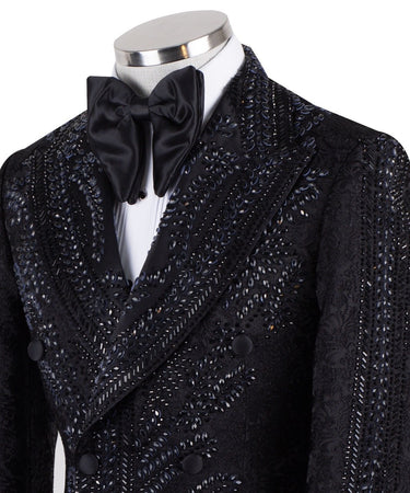 Front view of a luxurious black embellished jacquard double-breasted tuxedo jacket with intricate sequin and bead work on lapels, body, and sleeves, paired with black trousers, worn on a mannequin. From BTS Bespoke, handcrafted in Istanbul.
