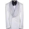 Full shot of a white double-breasted tuxedo with silver crystal-embellished shawl lapels and black trousers with satin stripes, displayed on a mannequin. Handcrafted luxury suit from BTS Bespoke.