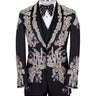 Front and side view of a black tuxedo jacket with extensive silver, purple, orange, and blue crystal and gemstone embellishments in floral and baroque patterns, paired with matching black trousers and vest, on a mannequin. Showcases intricate hand-embellished details and luxurious craftsmanship from BTS Bespoke, Istanbul.