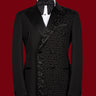 Front view of a black double-breasted tuxedo jacket with satin peak lapels and intricate hand-embellished black beading on the right side. Paired with matching trousers featuring a satin side stripe. High-end bespoke formal wear, handcrafted in Istanbul.