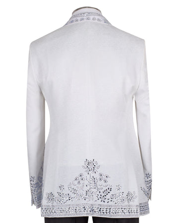Front view of a white heavily embellished three-piece tuxedo with silver sequins and beadwork, featuring a shawl lapel and a matching white vest, displayed on a mannequin. Handmade in Istanbul.