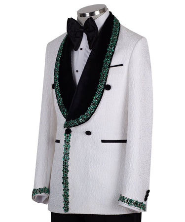 White double-breasted tuxedo jacket with textured fabric, black velvet shawl lapel, emerald green hand-embellished jewels, black buttons, and matching black trousers. Luxurious, handcrafted in Istanbul by BTS Bespoke.