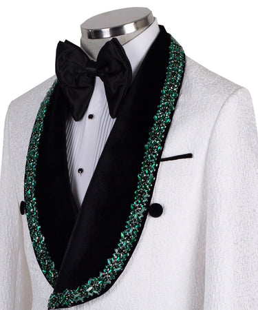 White double-breasted tuxedo jacket with textured fabric, black velvet shawl lapel, emerald green hand-embellished jewels, black buttons, and matching black trousers. Luxurious, handcrafted in Istanbul by BTS Bespoke.