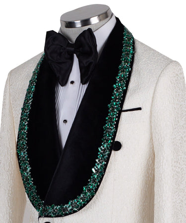 BTS Bespoke Cream textured double-breasted tuxedo with black velvet shawl lapel and emerald green hand-embellishments on jacket front, lapel, and cuffs, paired with black trousers.