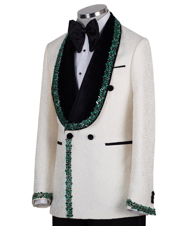BTS Bespoke Cream textured double-breasted tuxedo with black velvet shawl lapel and emerald green hand-embellishments on jacket front, lapel, and cuffs, paired with black trousers.