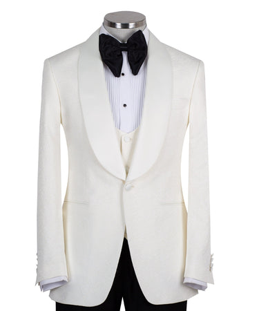 Front view of an ivory jacquard three-piece tuxedo with black trousers on a mannequin. Features a single-breasted jacket with a satin shawl lapel, matching U-neck vest, and subtle floral pattern. Ideal for weddings and formal events.